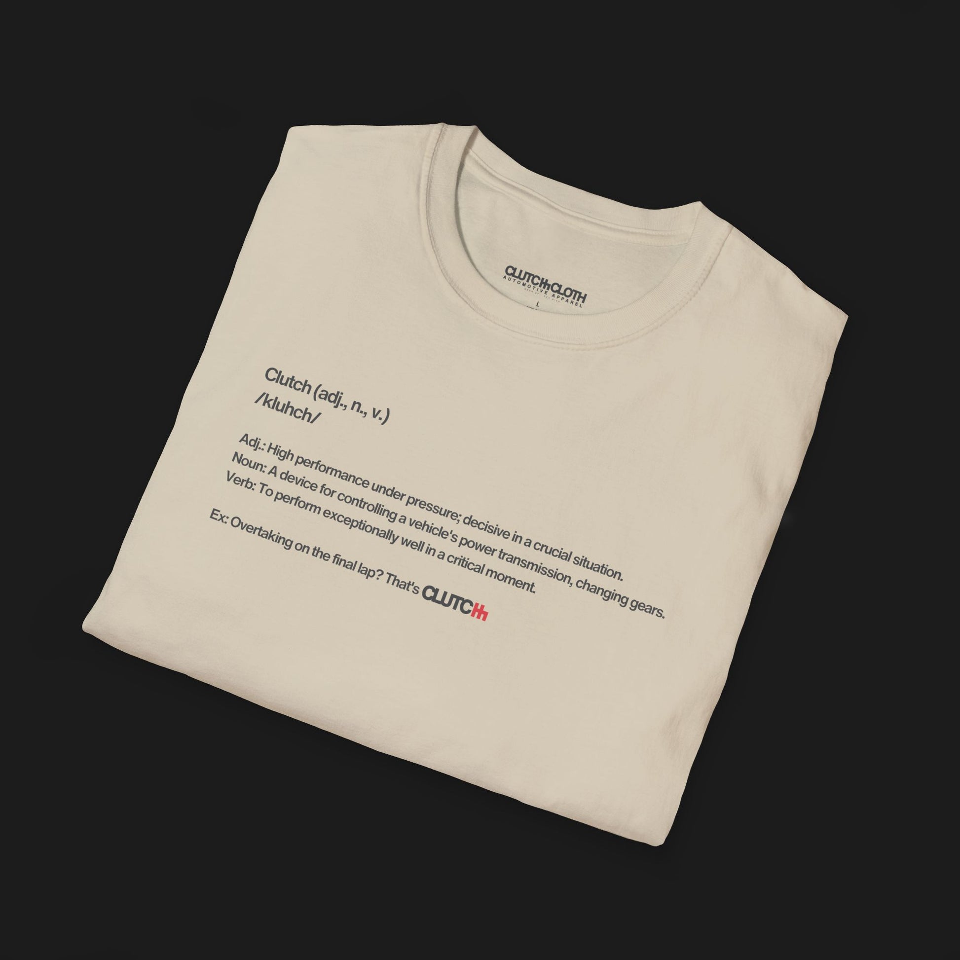 Folded Define Clutch Automotive Graphic T-Shirt – Sand unisex tee featuring the definition of 'Clutch' in a minimalist text design. A perfect gift for car enthusiasts and motorsport fans.