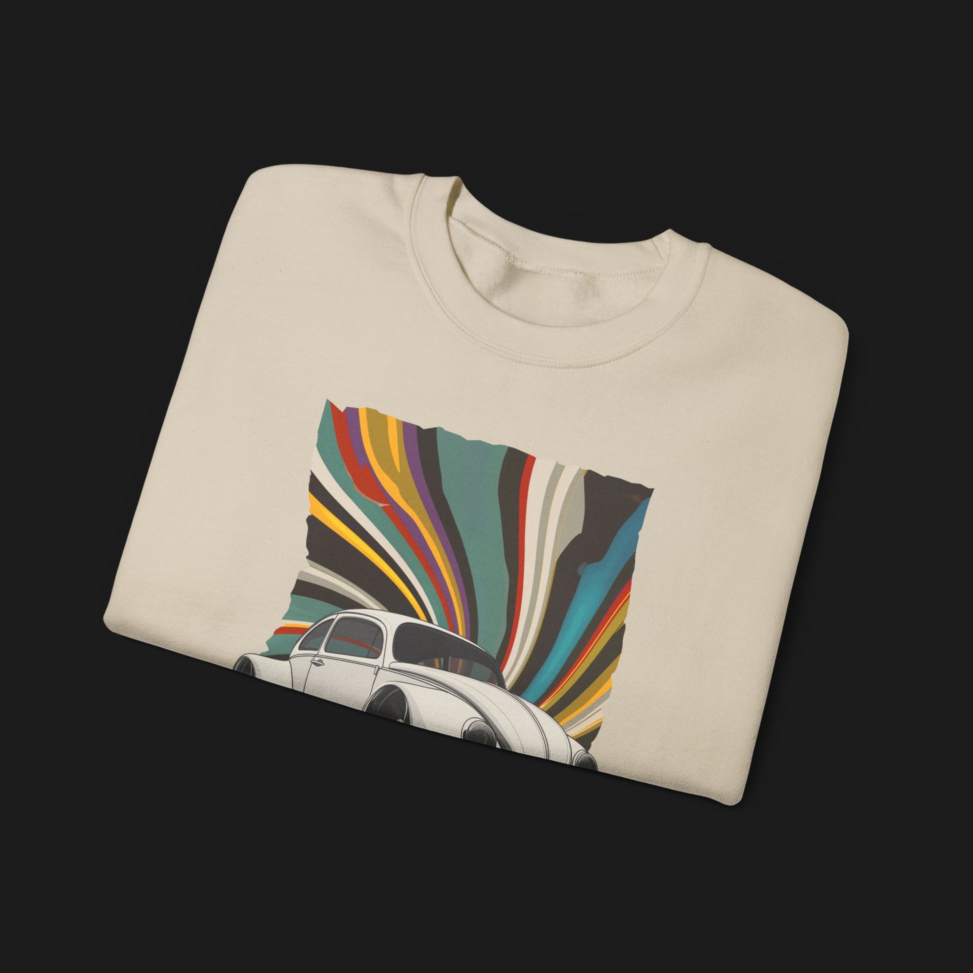 Folded Vintage Goods Bug Automotive Graphic Crewneck – Beige unisex sweater featuring a classic Volkswagen Beetle with a colorful retro swirl background. Ideal for vintage car enthusiasts and retro style lovers.