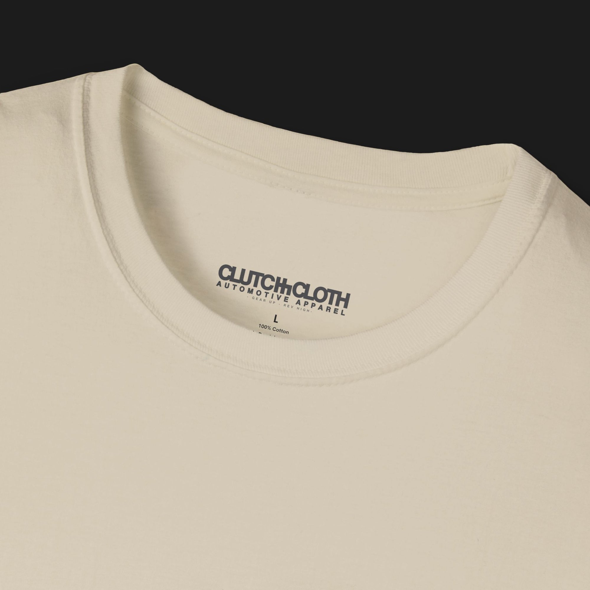 Collar of Clutch Classic Unlock The Garage Automotive Graphic T-Shirt – Sand tee featuring a small "Clutch Automotive Apparel" chest design. Perfect gift for car lovers and gearheads.