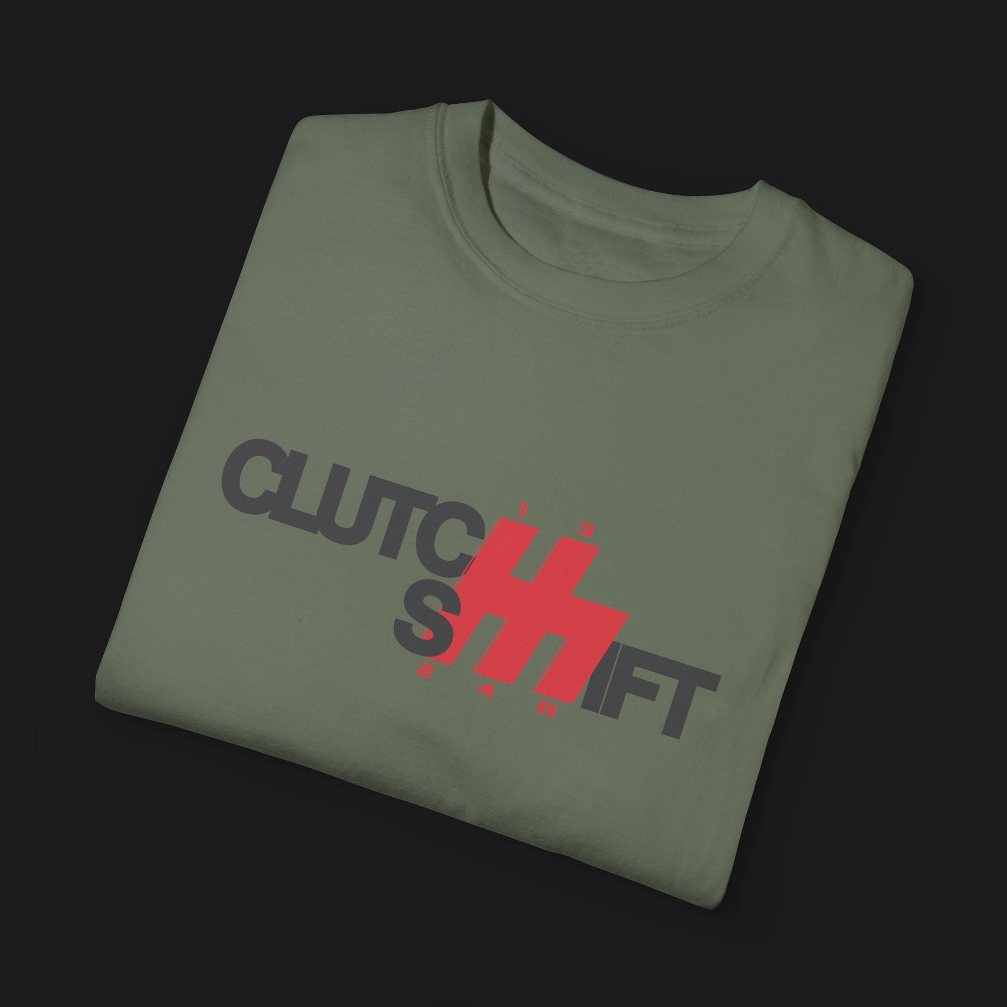 Folded Clutch Shift Automotive Graphic T-Shirt – Green tee with "Clutch Shift" text and red gear shift design. Perfect gift for car enthusiasts and motorsport fans.