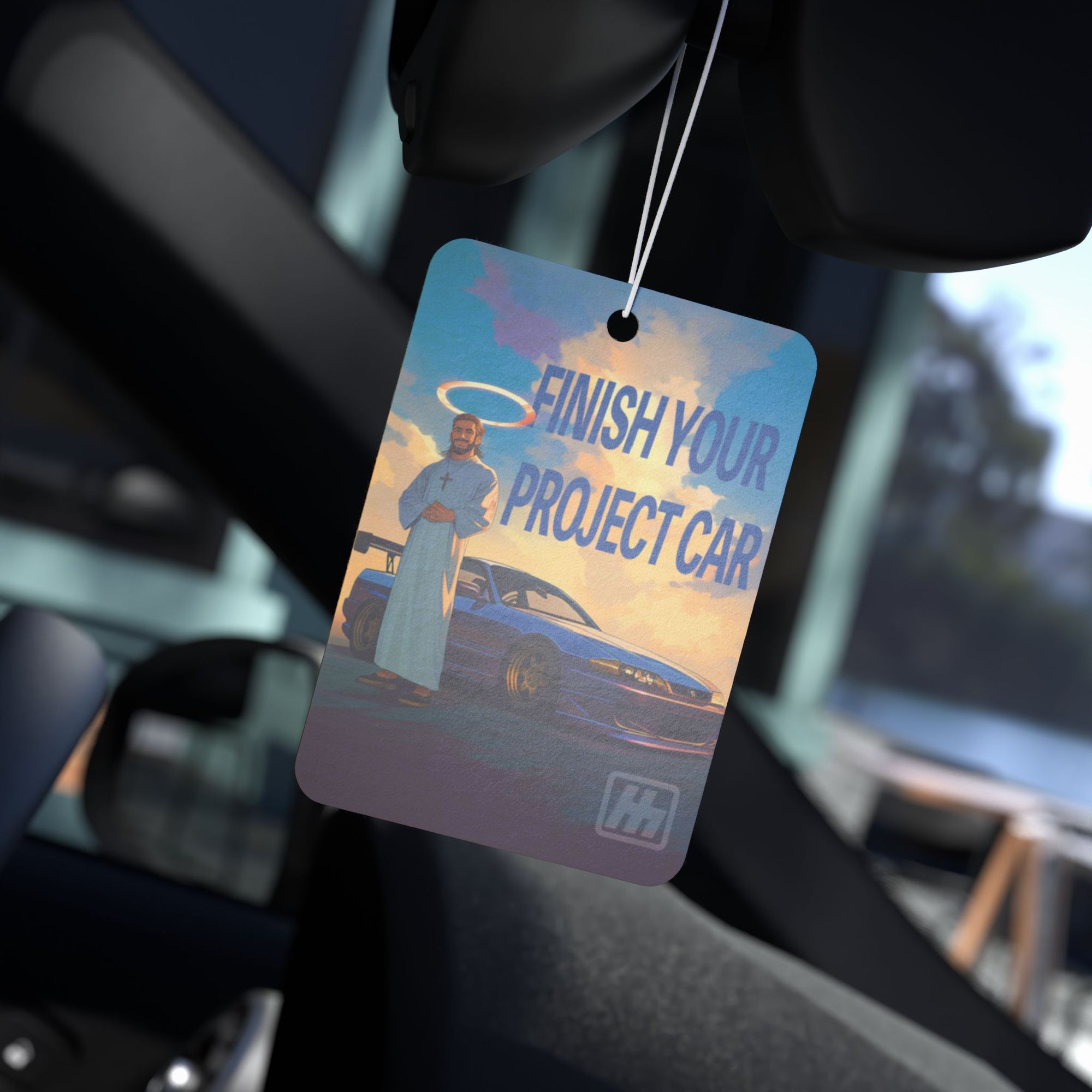 Premium car air freshener featuring a motivational "Finish Your Project Car" design with a car and halo figure background. Perfect for car enthusiasts looking to keep their ride smelling fresh and stylish.