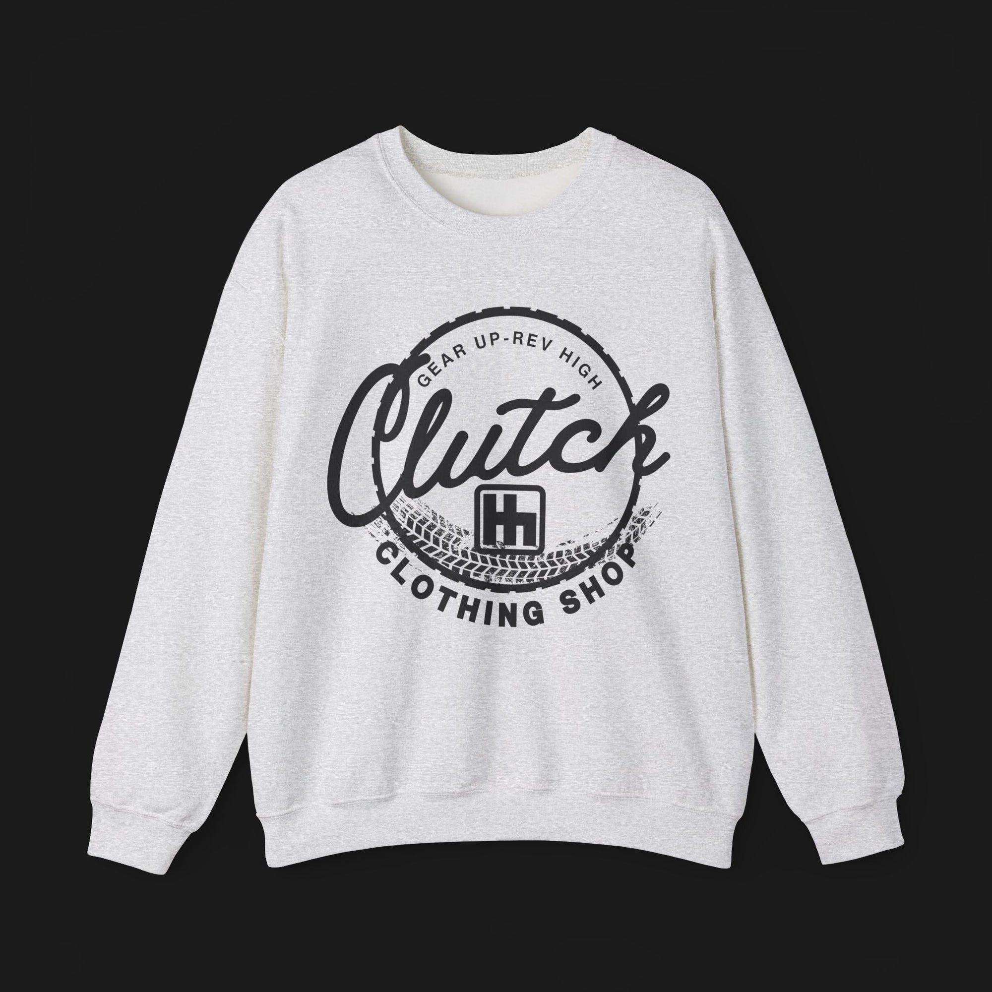 Front of Clutch Crewneck Automotive Sweater – Light grey unisex sweater featuring a bold 'Clutch Clothing Shop' design with a tire tread circle and stylized text. Perfect for car enthusiasts and casual wear.