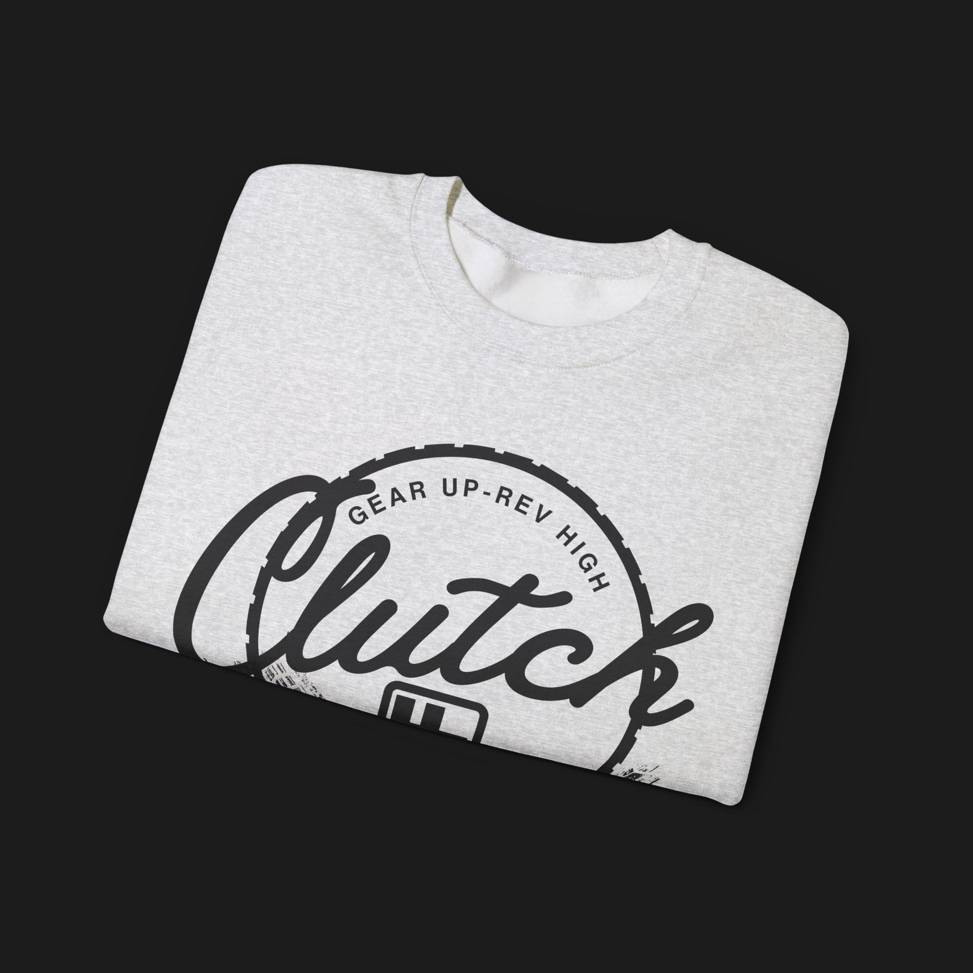 Folded Clutch Crewneck Automotive Sweater – Light grey unisex sweater featuring a bold 'Clutch Clothing Shop' design with a tire tread circle and stylized text. Perfect for car enthusiasts and casual wear.