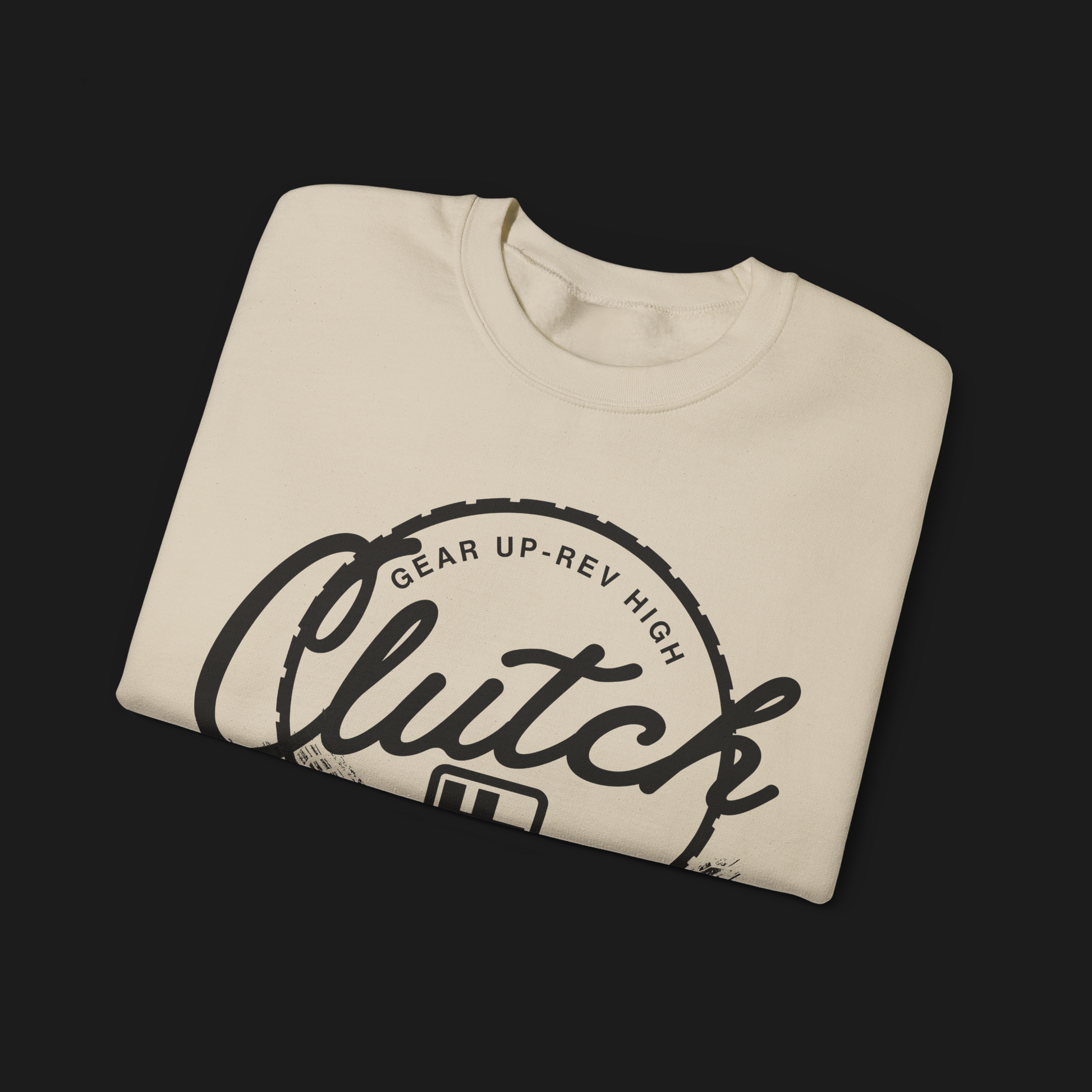 Folded Clutch Crewneck Automotive Sweater – Beige unisex sweater featuring a bold 'Clutch Clothing Shop' design with a tire tread circle and stylized text. Perfect for car enthusiasts and casual wear.