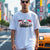 Man wearing 1970 2000GT-R Fuji Speedway Heritage Automotive Graphic T-Shirt – White unisex tee featuring a classic 1970 2000GT-R in front of a stylized Fuji Speedway background in red and white. Ideal gift for vintage car enthusiasts and JDM lovers.