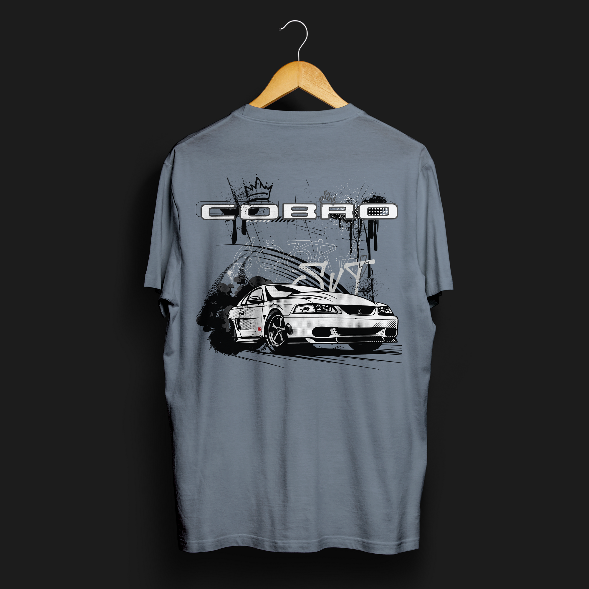 Back angle of Cobro x Clutch Automotive Graphic T-Shirt – Blue tee featuring a detailed white Mustang Cobra design with graffiti-style background and "Cobro" text. Perfect gift for Mustang fans and car enthusiasts.