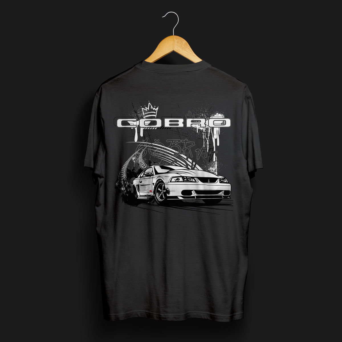 Back angle of Cobro x Clutch Automotive Graphic T-Shirt – Black tee featuring a detailed white Mustang Cobra design with graffiti-style background and &quot;Cobro&quot; text. Perfect gift for Mustang fans and car enthusiasts.