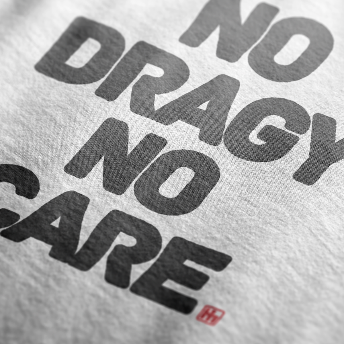 Close up design angle for No Dragy No Care Automotive Graphic T-Shirt – tee with bold "No Dragy No Care" text design in black. Ideal gift for car culture fans and automotive enthusiasts.