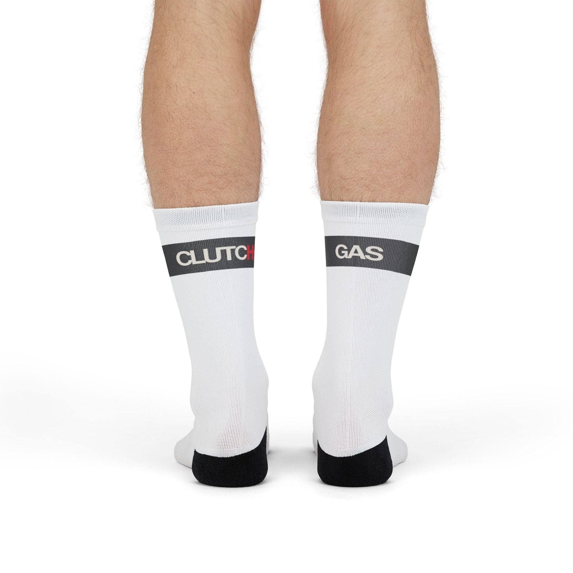 Back of man wearing Driving Lessons Crew Socks – White and black unisex crew socks featuring "GAS" and "CLUTCH" labels on the toes and heel. Comfortable and stylish, designed for automotive enthusiasts. Ideal gift or stocking stuffer for men and women who love cars and driving culture