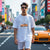 Man wearing FF Supra Buster Automotive Graphic T-Shirt – White unisex tee featuring an orange Toyota Supra with Japanese text and a grey 'SUPRA' background. Ideal gift for JDM fans and car enthusiasts.