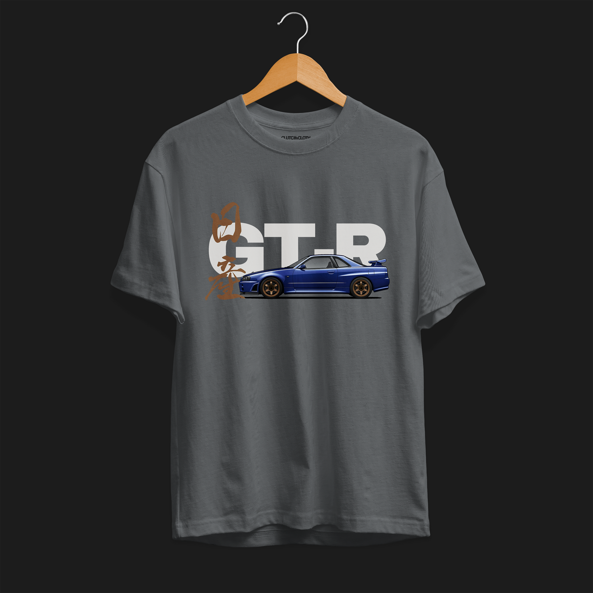 Front of Charcoal R34 GT-R Automotive Graphic T-Shirt featuring a blue Nissan Skyline with gold accents and Japanese calligraphy design, unisex car enthusiast gift