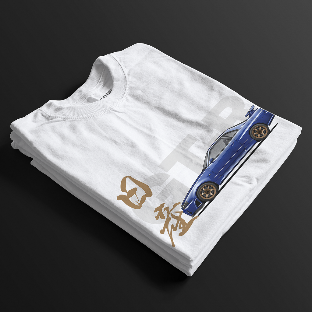Folded White R34 GT-R Automotive Graphic T-Shirt featuring a blue Nissan Skyline with gold accents and Japanese calligraphy design, unisex car enthusiast gift