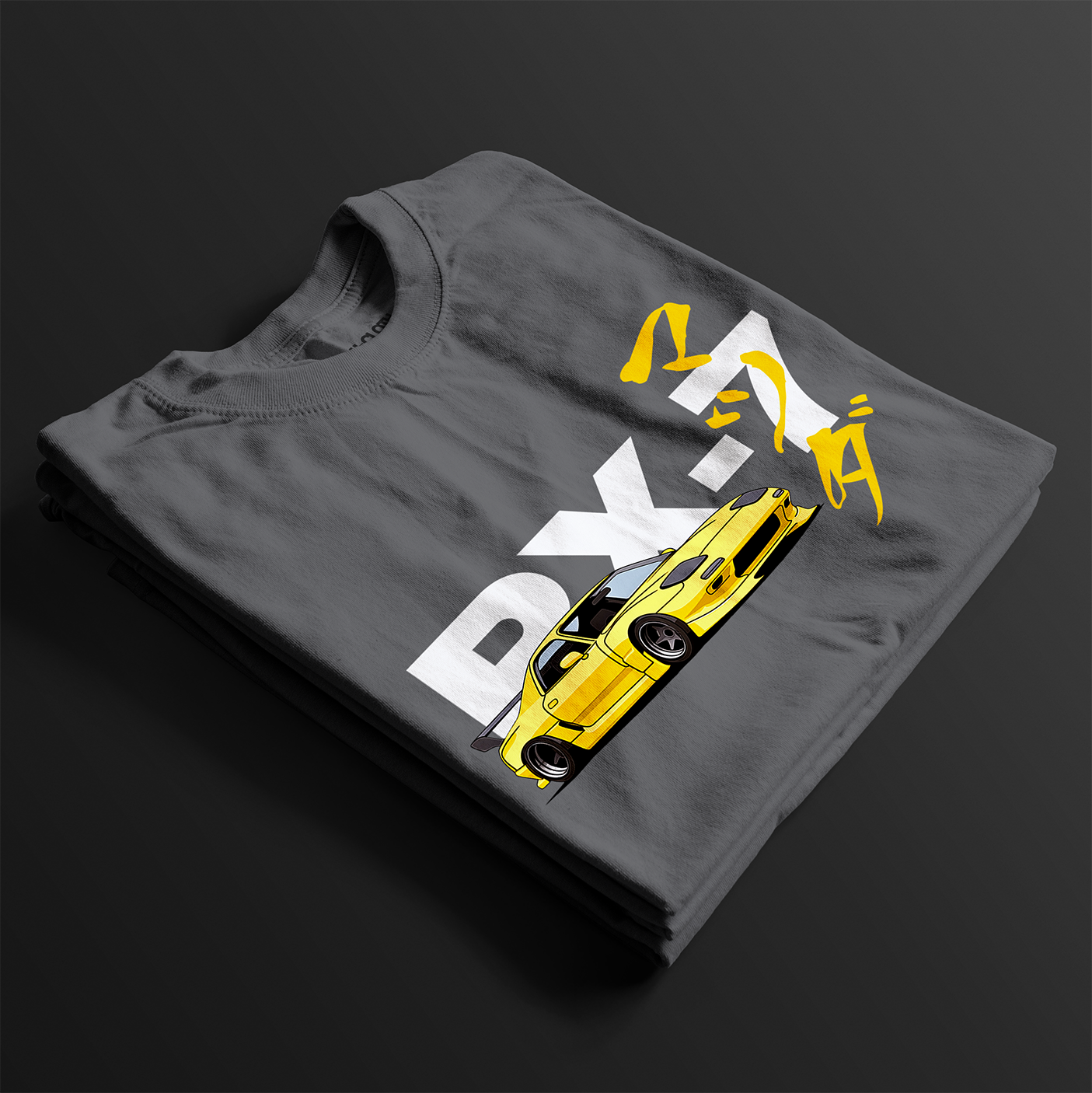 Folded Charcoal RX-7 Rotary Legend Automotive Graphic T-Shirt featuring a yellow Mazda RX-7 with Japanese text and RX-7 lettering, unisex car enthusiast gift