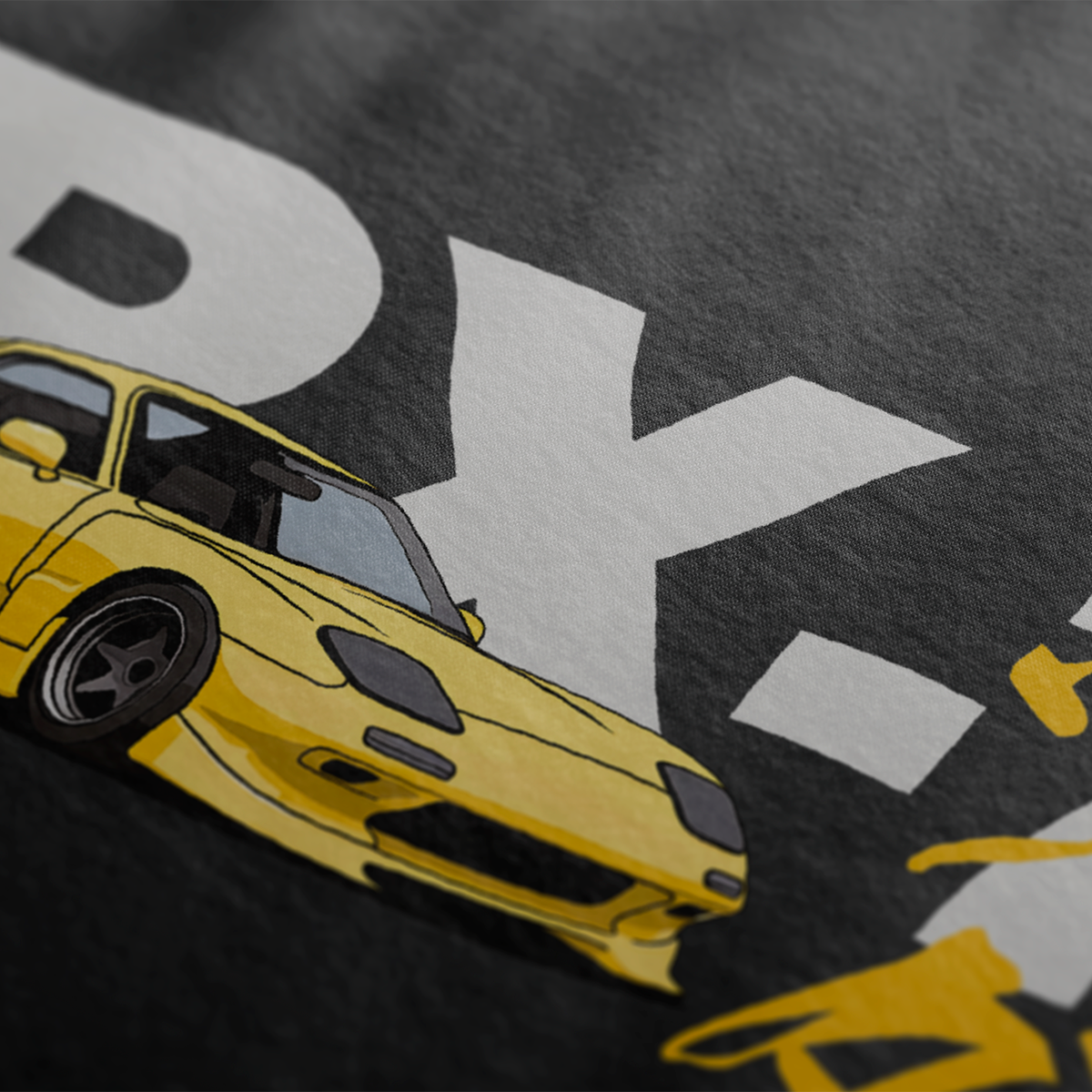 Close up of Black RX-7 Rotary Legend Automotive Graphic T-Shirt Design featuring a yellow Mazda RX-7 with Japanese text and RX-7 lettering, unisex car enthusiast gift