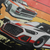 Close up of Racing Sport Rally Sunset Automotive Graphic T-Shirt Design – unisex tee featuring a rally car and a vintage car against a bold sunset background in shades of red, orange, and yellow. Ideal gift for car and motorsport enthusiasts.