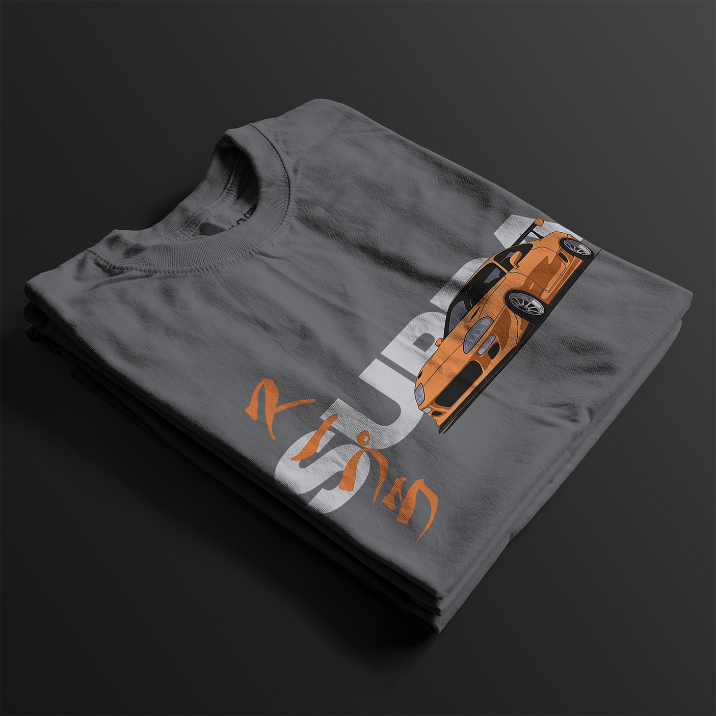 Folded FF Supra Buster Automotive Graphic T-Shirt – Charcoal unisex tee featuring an orange Toyota Supra with Japanese text and a grey 'SUPRA' background. Ideal gift for JDM fans and car enthusiasts.